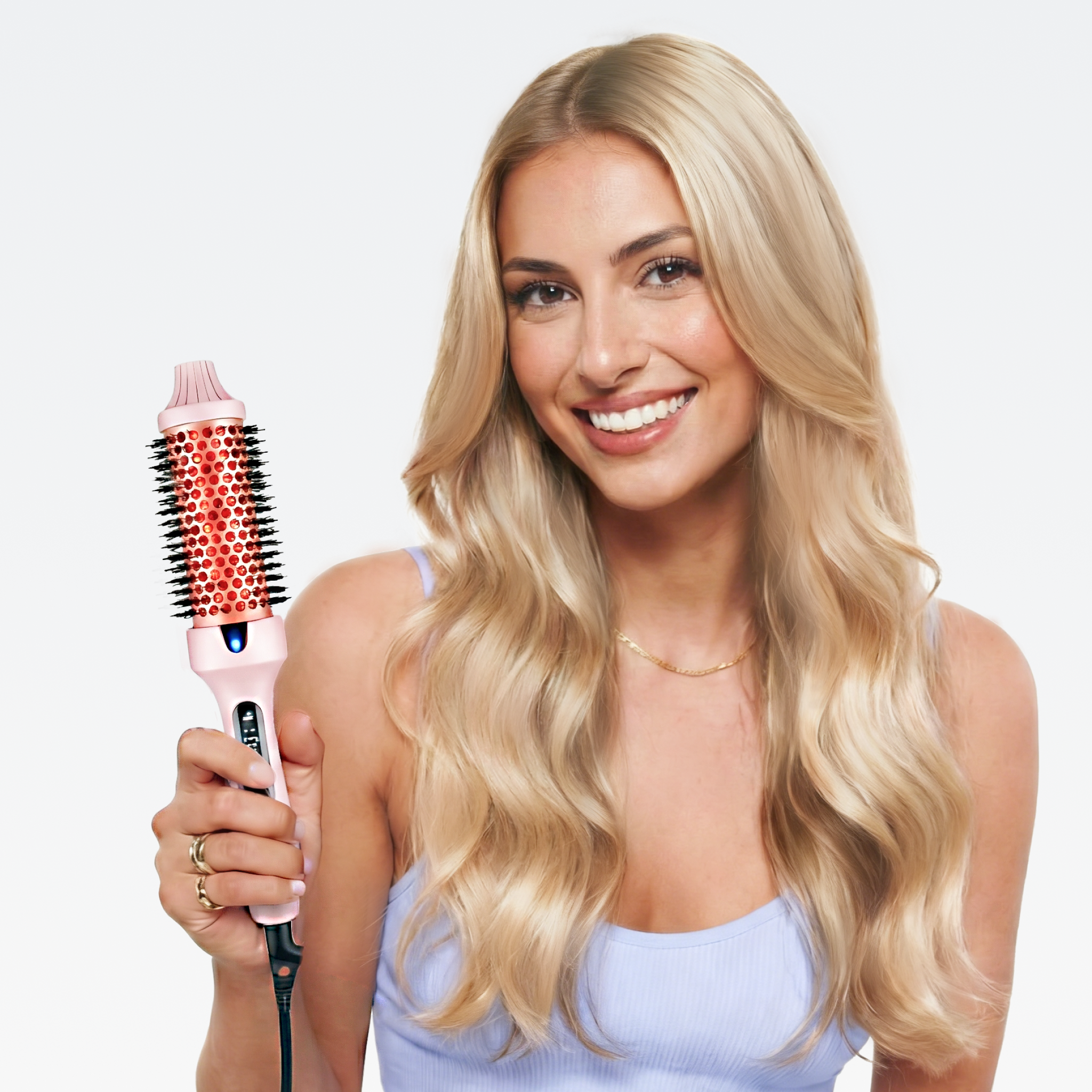 Glückliche Frau mit blonden Haaren präsentiert die rosa Hyeton Ionen-Glättbürste STYLUX für voluminöses Haar
