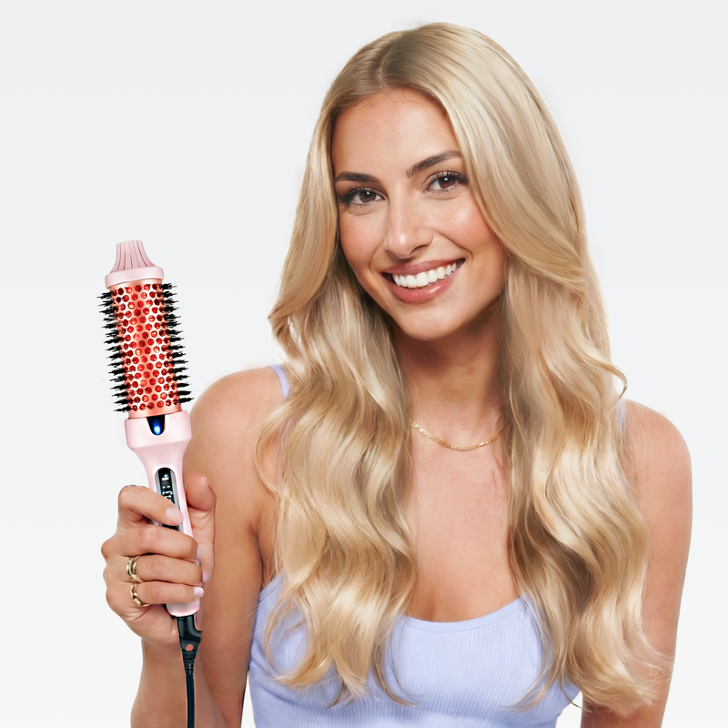 Glückliche Frau mit blonden Haaren präsentiert die rosa Hyeton Ionen-Glättbürste STYLUX für voluminöses Haar